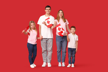 Beautiful family with flags of Canada on red background