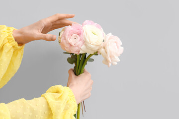 Female hands with beautiful ranunculus flowers and eucalyptus on white background