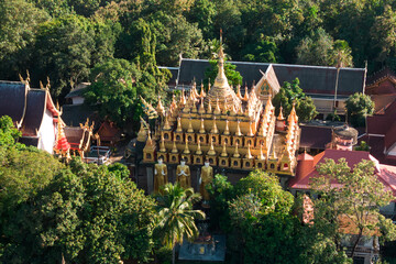 Top view of golden pagoda and church at Wat Phra That Suthon Mongkhon Khiri Samakkhitham. It is a...