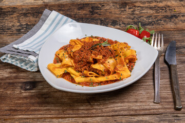 An Italian dinner of Rigatoni Bolognese, pasta with a savory ground beef sauce flavored with rosemary