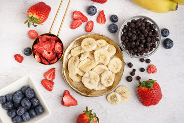 Tasty freeze-dried bananas and berries on white background