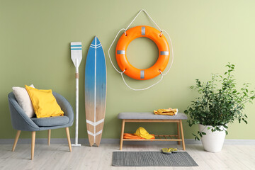 Interior of living room with surfboard, armchair and ring buoy