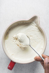 Overhead view of homemade greek yogurt in a spoon, trained thick yogurt in a spoon, process of making Greek yogurt