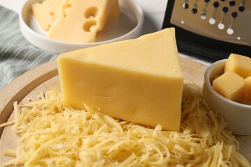 Grated and whole pieces of cheese on table, closeup