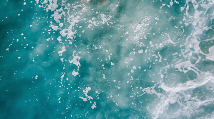 Obraz premium Aerial view of turquoise ocean waters with a textured overlay of white sea foam creating a dynamic and natural abstract surface perfect for backgrounds and aquatic-themed projects