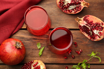 Tasty pomegranate juice in glasses and fresh fruits on wooden table, flat lay