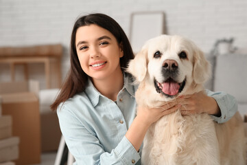 Young happy woman and cute Labrador dog on moving day at home