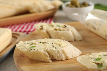 Tasty butter with spices and bread on table, closeup