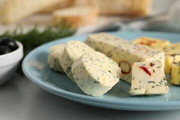 Tasty butter with herbs and spices on white table, closeup