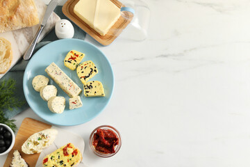 Different types of tasty butter, dill, chili and bread on white marble table, top view. Space for...