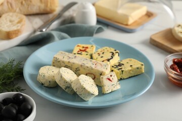 Different types of tasty butter, dill, olives and bread on white table