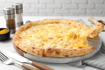 Taking piece of delicious cheese pizza at white table, closeup