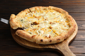 Taking piece of delicious cheese pizza at wooden table