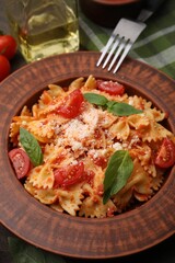 Tasty pasta with tomato, cheese and fork on table, closeup