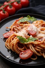 Tasty pasta with tomato sauce, cheese and basil on table, closeup