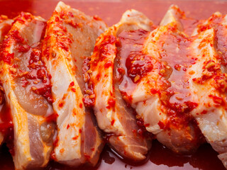 Pork chops in red Asian style marinade with chilly pepper. Fine pork meat for grill or summer...