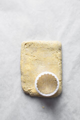 Raw scone dough on a parchment lined baking sheet, process of making scones