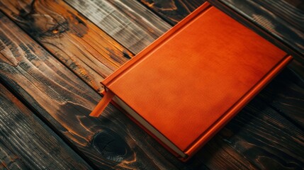 Orange book on wooden surface
