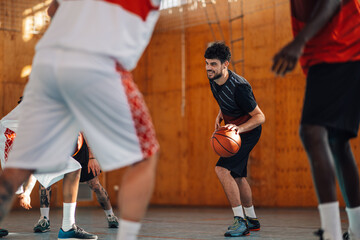Portrait of a caucasian man in a sportswear playing basketball in indoor court