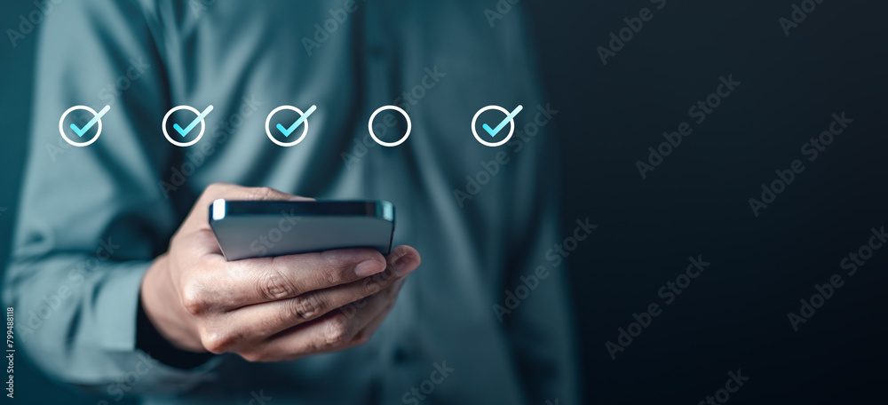 Sticker checklist, list, check, marketing, smartphone, question, tick, touch, information, mark. A man is holding a cell phone with a check mark on it. Concept of a person checking something.