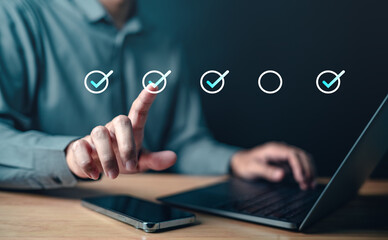checklist, check, choice, management, marketing, report, click, strategy, analysis, support. A man is pointing at a laptop screen with a thumbs up on it. The laptop screen has a check mark on it.