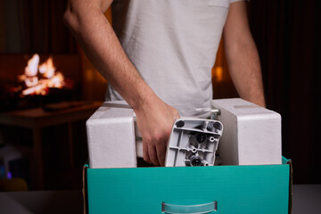 The hands of a young guy installing a computer monitor