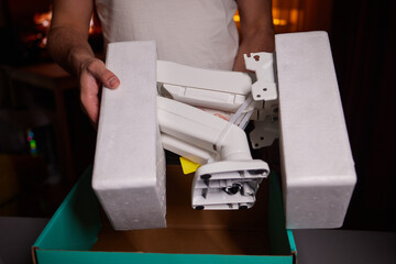 The hands of a young guy installing a computer monitor
