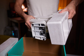 The hands of a young guy installing a computer monitor