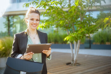 smiling female worker near business center using digital tablet