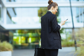 business woman near business center using phone and walking
