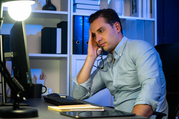 Working businessman sleepy feeling with project at night time, waiting email information sending...