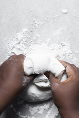 Fototapeta premium Hands kneading white fondant for decorating cake, fondant being mixed on a table
