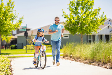 Fototapeta premium father and son in fatherhood. fatherhood of father and son cycling at sunlit park. father and son navigate the winding paths together at fatherhood. father and son promenade. Pedaling together