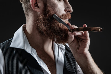 Bearded hipster barber isolated on black. Man beard haircut by hairdresser at barbershop. Handsome...
