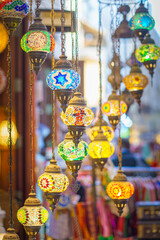 Close-up view of multicolored antique glass lamps and lanterns with patterns, in souvenir shop, at...