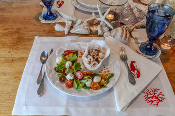 Seafood mix and Caprese salad with cherry tomatoes, mozzarella, basil, and arugula