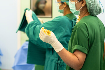 Medical team of surgeons in hospital working surgical intervention.Doctor wearing sterile white gloved preparing gurgical.
