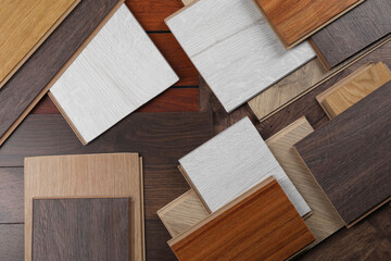 Different samples of wooden flooring as background, flat lay