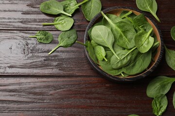 Fresh spinach leaves on wooden table, flat lay. Space for text