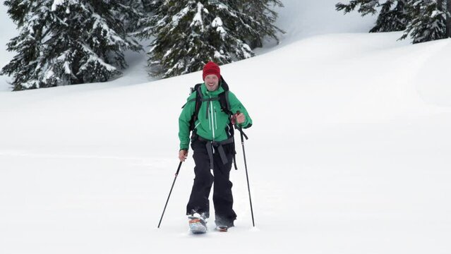 Man Hiking in Backcountry Powder Snow with Splitboard and Poles
