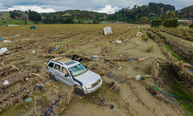SUV and farm equipment sprawled over a destroyed vineyard from the Cyclone Gabrielle natural...