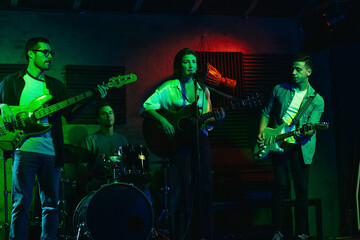 Musicians In Stage With Colorful Lights Performing In A Live Concert