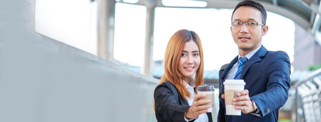 Banner Asian Business people smiling Relax holding cup of coffee in modern city. Couple lover enjoy...