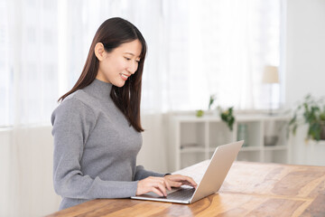 部屋でラップトップコンピューターを見る女性