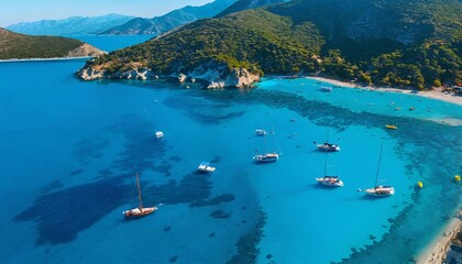 An aerial view showcasing a Mediterranean Sea bay featuring mountains, a sandy beach, and boats on a sunny day during summer.