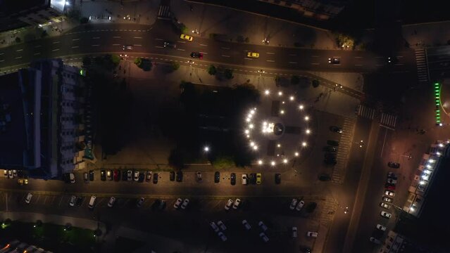 4k drone footage. The top view of memorial of Rebirth, Revolution Square and the streets Bucharest city. The atmosphere of a European capital at night. The camera moves in the cars moving direction.