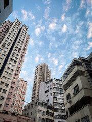 Fototapeta premium Vintage City Towers Reaching for the Cloudy Sky, Hong Kong