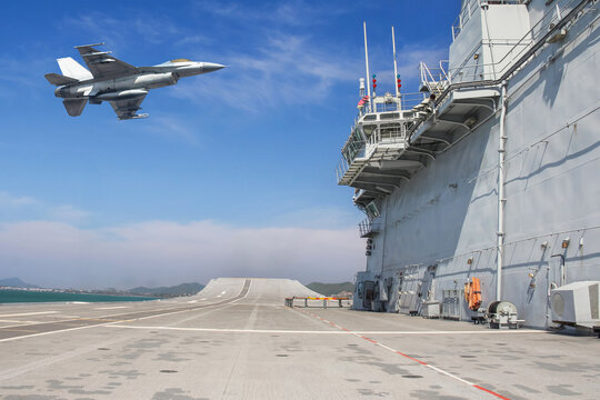 Military fighter jet warplane flying over aircraft carrier with blue sky
