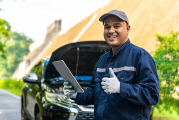 Happy asian automobile mechanic repairman wearing uniform and holding tablet, He standing and thumbs up to camera After repairing the car, car service and maintenance, Repair service.