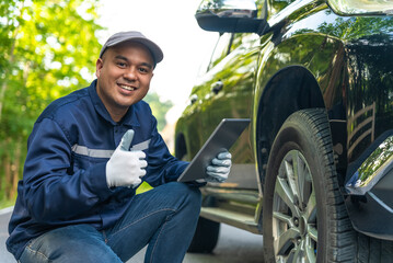 Happy professional asian automobile mechanic repairman wearing uniform and protection glove...